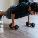 man in black t-shirt and black shorts doing push up